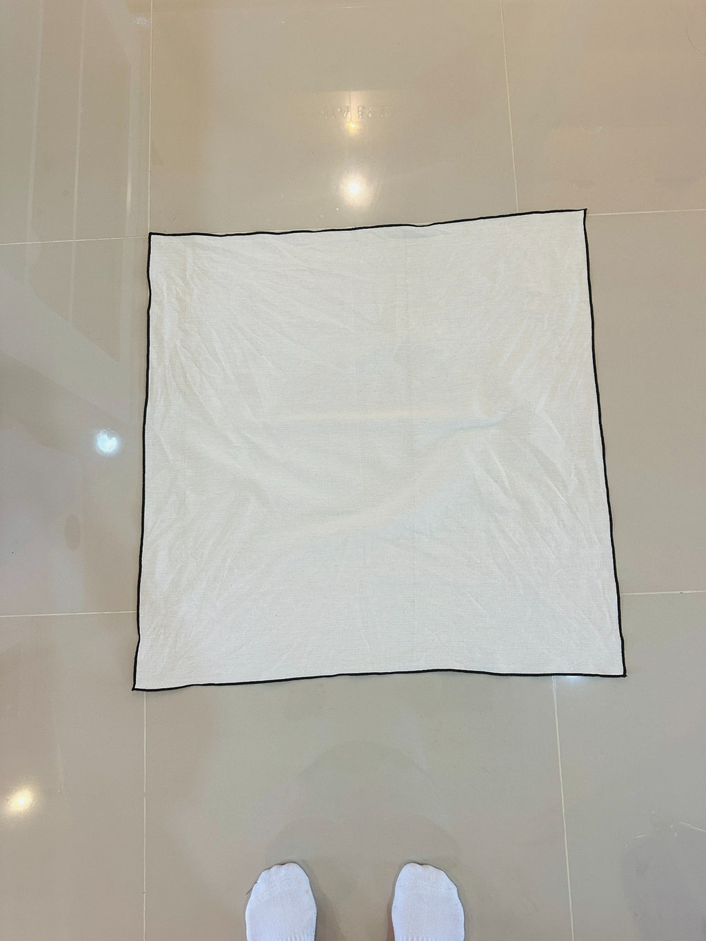 Natural fabric bojagi laid flat with brown border